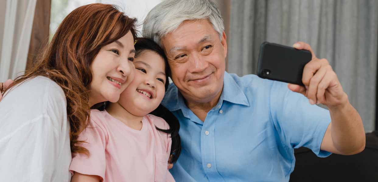 an older man taking a picture with two young girls.