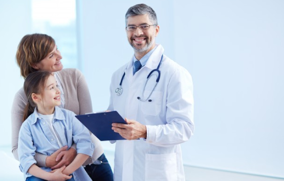 a male doctor is holding a clipboard with a little girl.